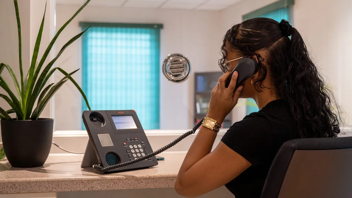 AZERRA receptionist answering a call at the front desk in Paramaribo